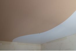 Натяжной потолок двухцветный с криволинейной спайкой