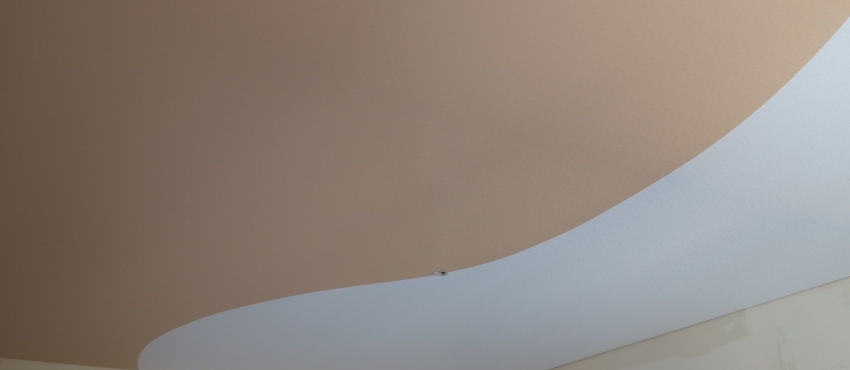 Двухцветный с криволинейной спайкой натяжной потолок фото №1